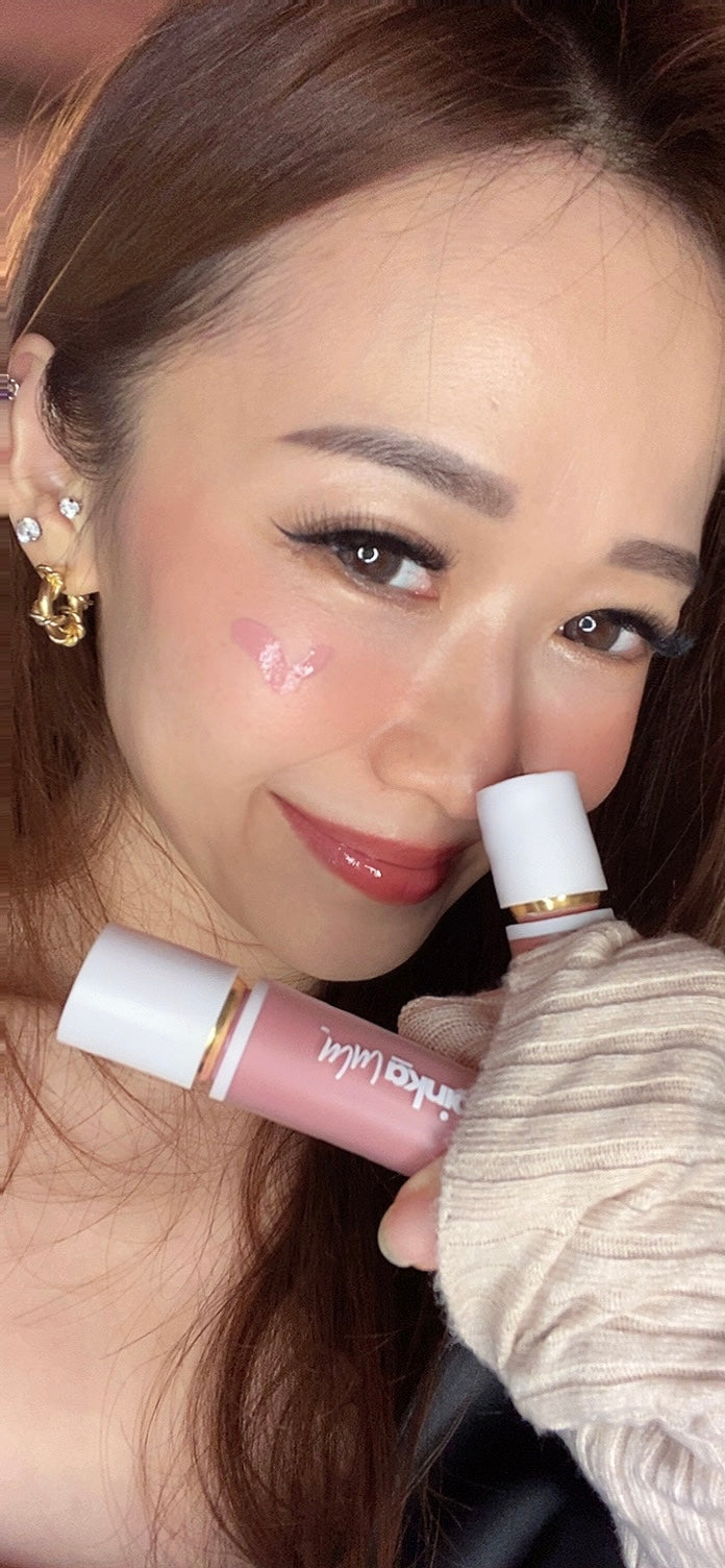 Woman holding two lip products close to her face