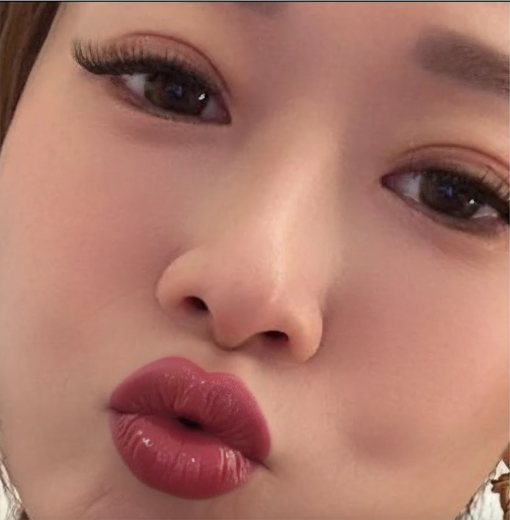 Close-up of a person's face with dark lipstick