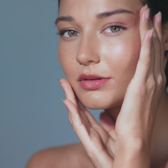 A woman touching her face with Pinkalulu pocket beauty lock glow
